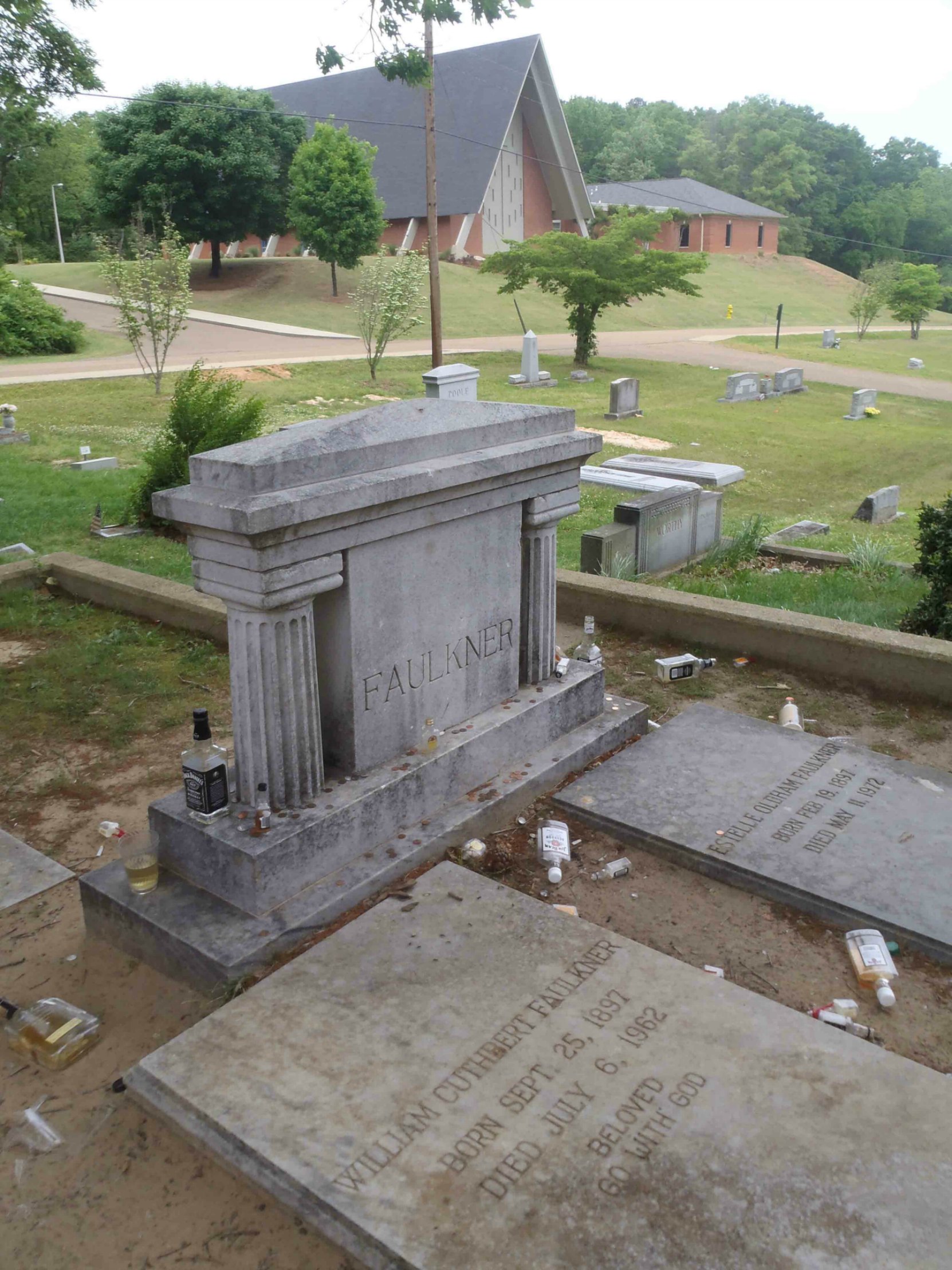 William Faulkner's grave in Oxford, Mississippi. The liquor bottles are tributes left at the grave by William Faulkner's fans.